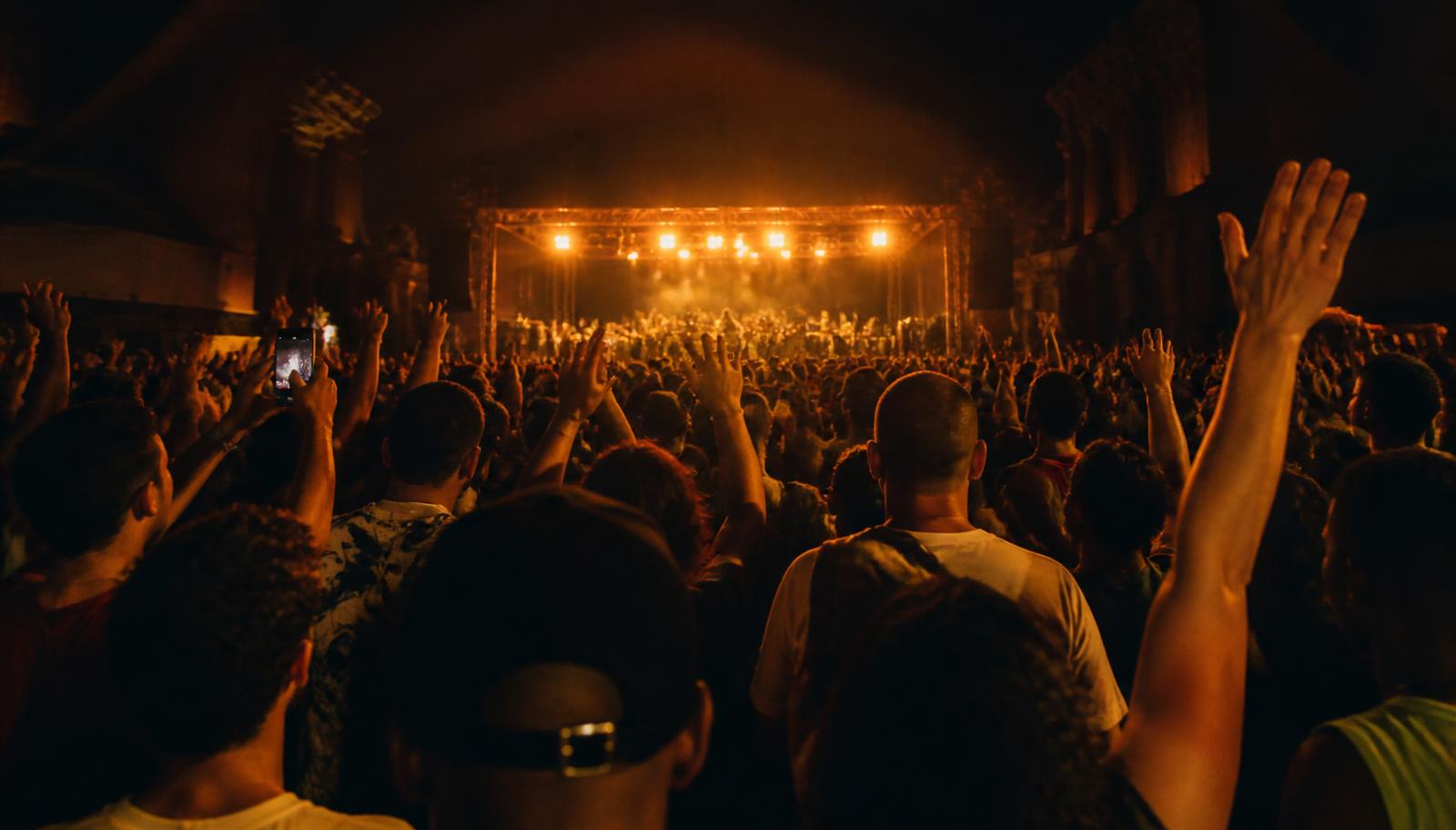 Público de braços erguidos em uma noite de show